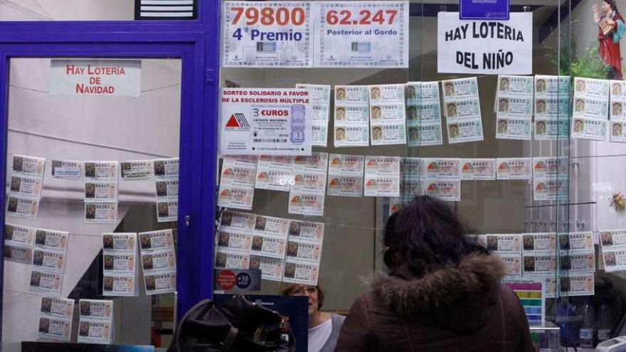 Una mujer compra lotería, ayer, en una administración de Galicia. javier de la fuente