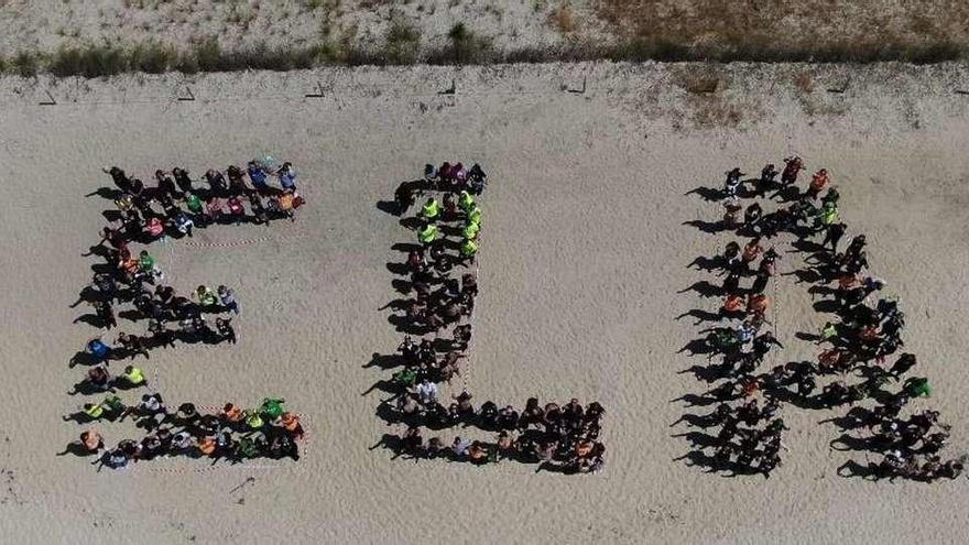 El primer Día Internacional de la ELA sin Tino Guimerans  |  Cangas celebró ayer la primera edicion de &quot;Eu móveme por ti&quot; que organiza la Asociación Gallega de Esclerosis Lateral Amiotrófica (AGAELA) sin su principal precursor, el cangués Agustín Guimerans, Tino, que fue presidente de este colectivo. Guimerans falleció el pasado 1 de mayo a los 62 años. Su lucha sigue siendo un ejemplo de vida no solo para los enfermos, sino también para los profesionales médicos. En la imagen, un grupo de participantes forman las siglas de la ELA en la playa.