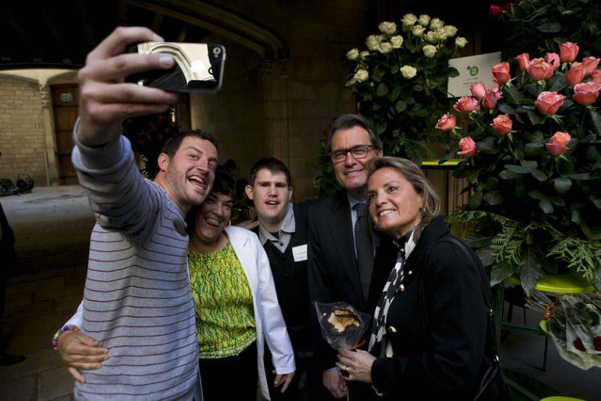 Artur Mas i Helena Rakosnik es fan un ’selfie’ amb nois de l’obrador El Rosal de l’Associació Alba.