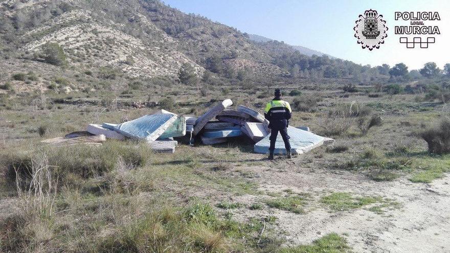 Un agente de la Policía junto a los colchones abandonados en el Puerto del Garruchal.