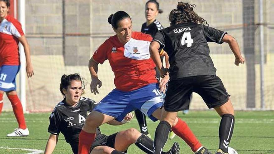 Pili Espadas pelea la pelota con dos jugadoras del Alcaine.