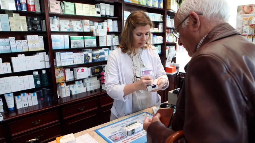 Un paciente recoge sus medicinas en una farmacia. // Bernabé / Luismy