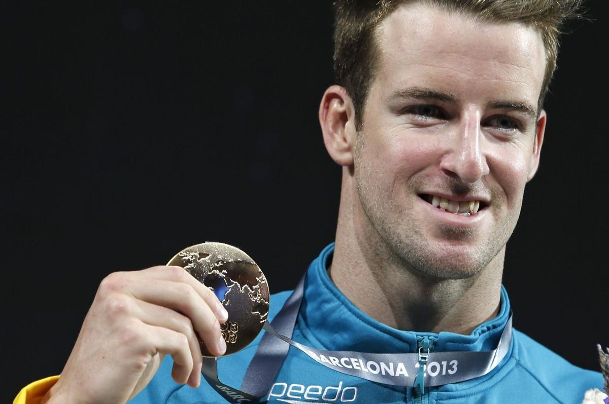 FILE - Australia's James Magnussen smiles as he hold the gold medal he won in the Men's 100m freestyle final at the FINA Swimming World Championships in Barcelona, Spain, on Aug. 1, 2013. (AP Photo/Michael Sohn, File). FILE PHOTO
