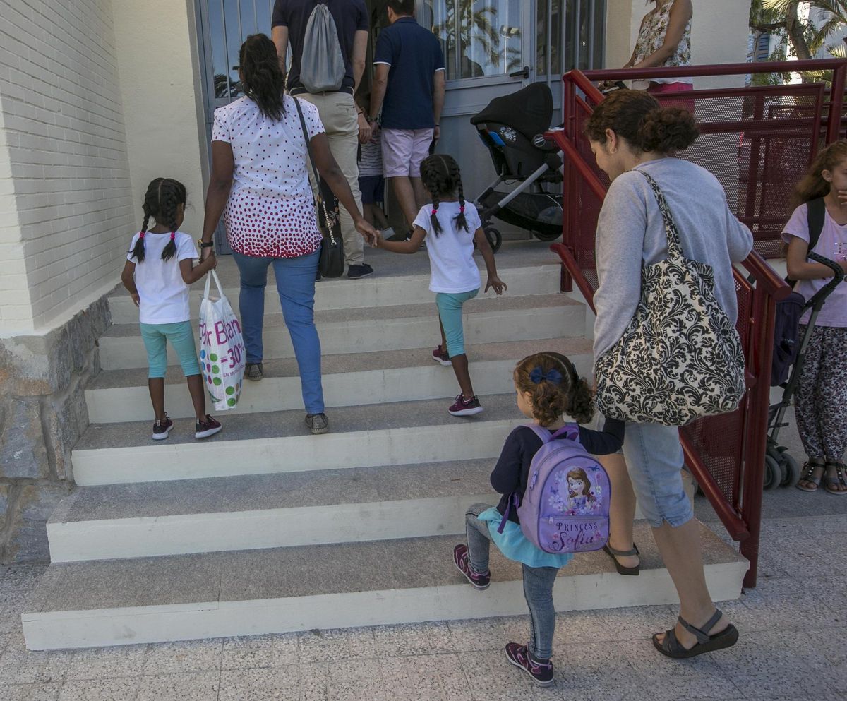 Niños entrando a un colegio con sus familias, en imagen de archivo