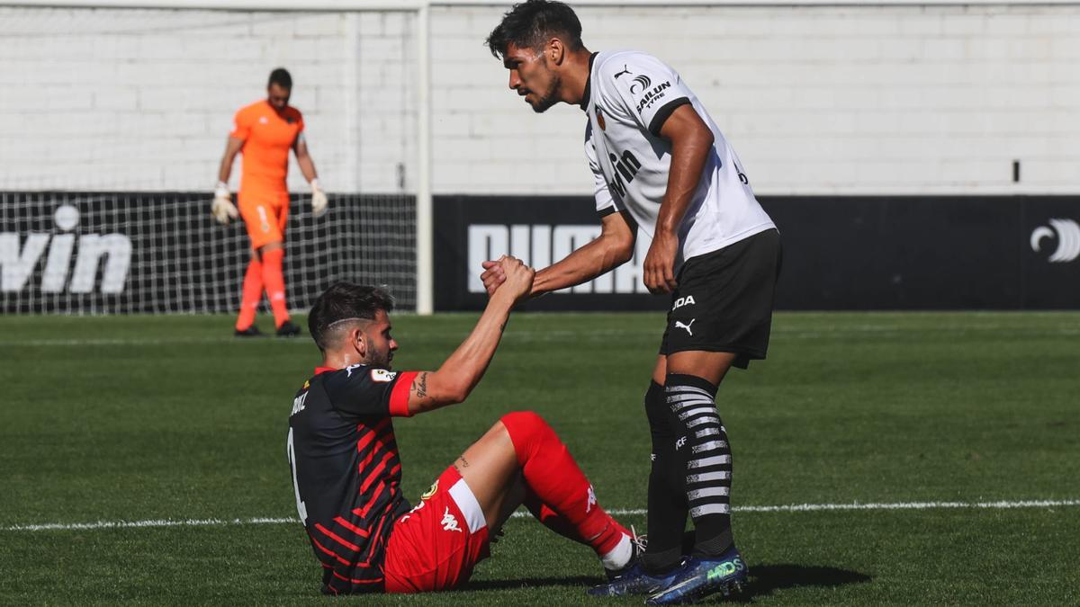 Facu ayuda a levantarse a Raúl Ruiz, durante el partido en Paterna.