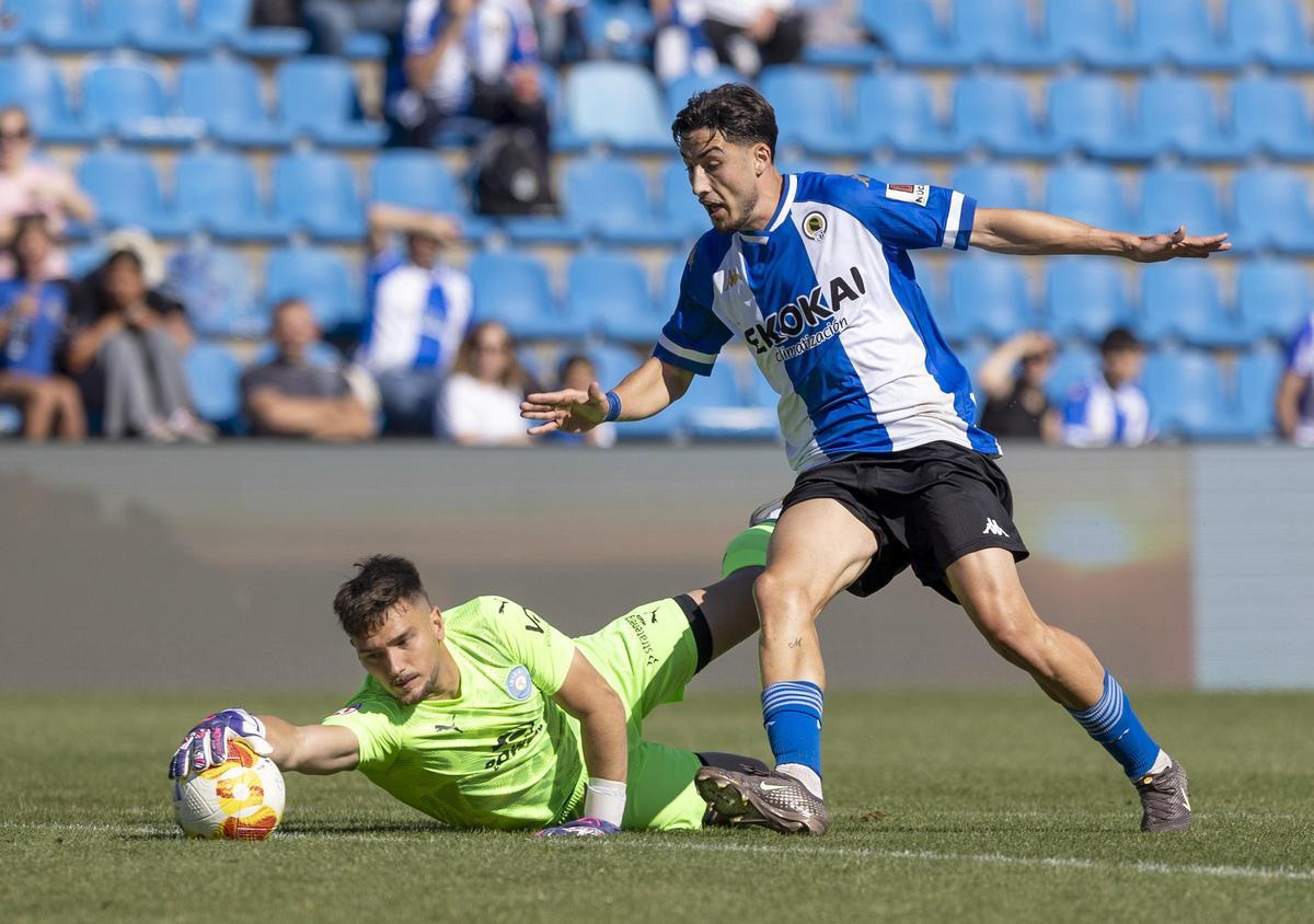 Unai Ropero intenta llegar al balón mientras el portero del Ibiza, Juan Ramírez, se lanza para desactivar la jugada.
