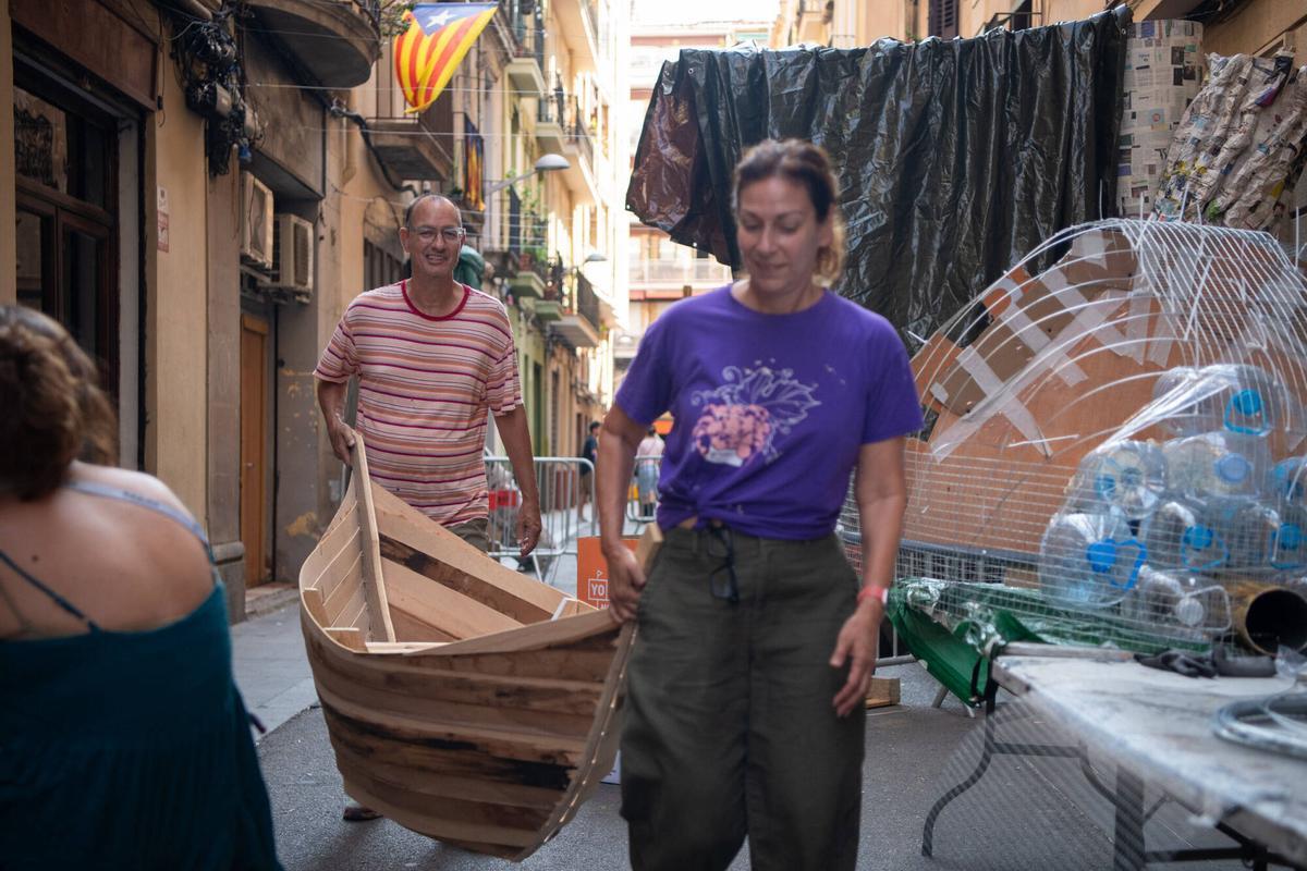 Dos vecinos de la calle Llibertat, durante la creación de los ‘guarnits’ de las fiestas mayores de Gràcia. Este año, 5 calles del barrio se han unido bajo la temática de ‘El Señor de los Anillos’. Barcelona, 4 de agosto de 2026. Foto: Belén González / EP
