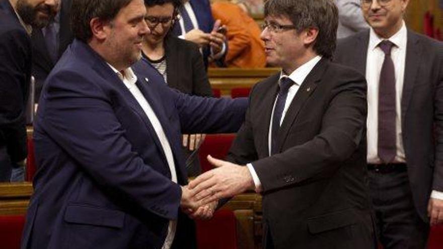 Oriol Junqueras i Carles Puigdemont se saluden a la cambra catalana