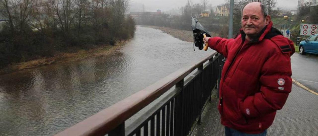 José Francisco García señala al fondo al hospital desde una zona afectada por las inundaciones.