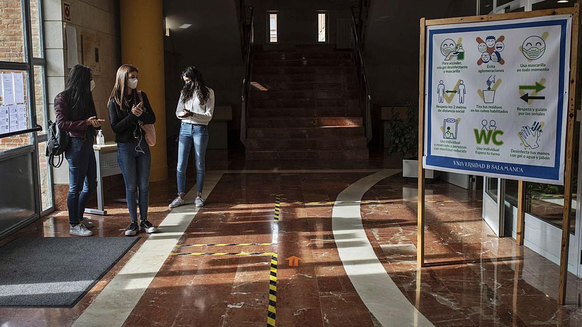 Tres alumnas en el hall del campus preparado con las medidas de prevención. | Emilio Fraile