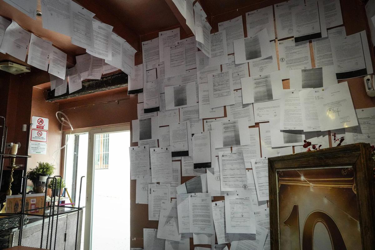 Algunas de las actas de denuncia que decoran su bar.