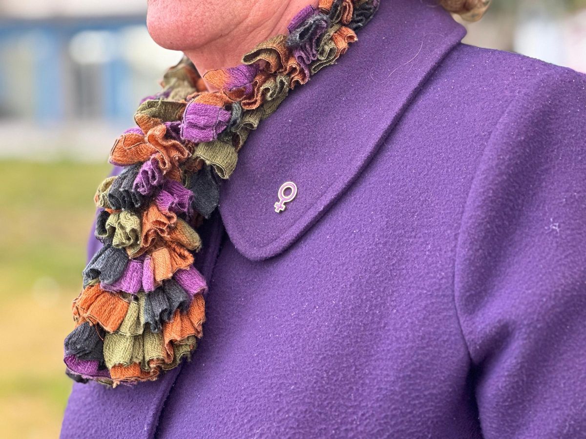 El pin con el símbolo femenino de María Reyes.