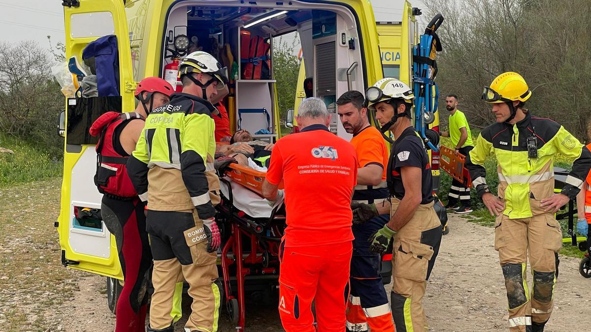 Sanitarios y bomberos introducen al joven herido en el molino de Casillas en la ambulancia.