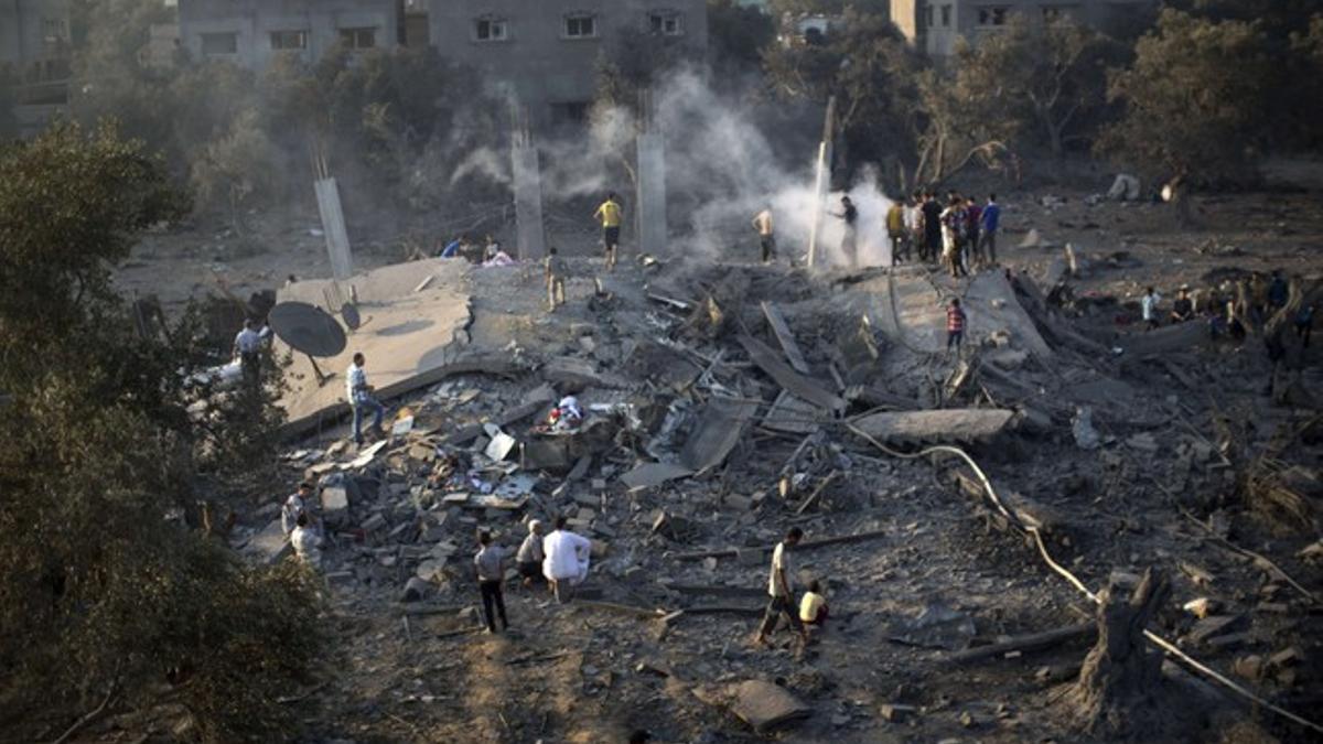 Un grupo de palestinos inspecciona los restos de casas bombardeadas por el Ejército israelí, este martes en Gaza.