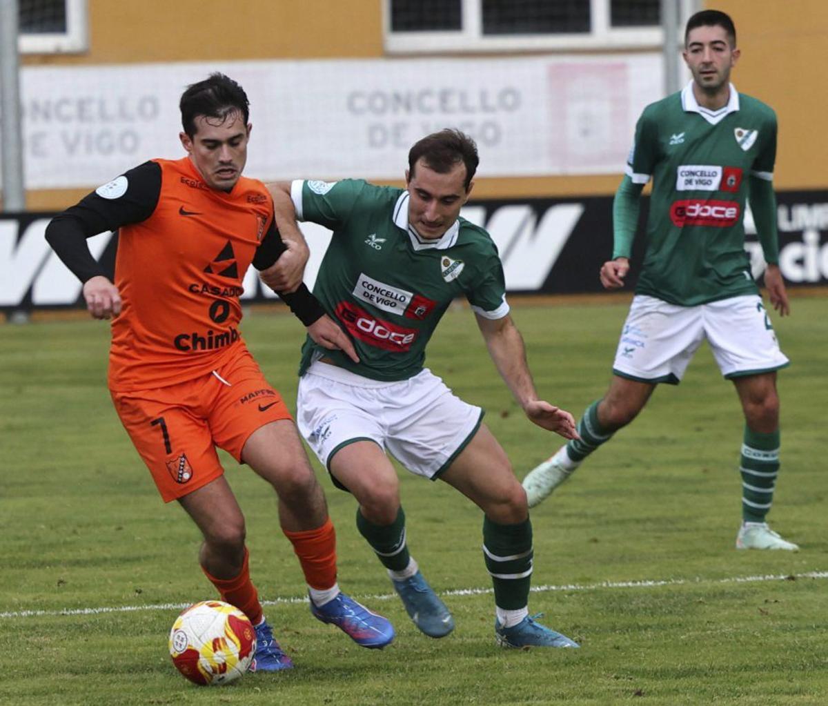 Mateo, del Coruxo, lucha con un jugador del Sámano durante el partido de ida disputado en O Vao. | JOSÉ LORES