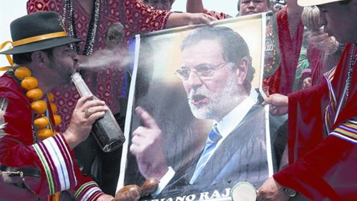 ENERGÍA CHAMÁNICA PARA EL PRESIDENTE 3 Un brujo quechua escupe sobre un retrato de Mariano Rajoy durante un ritual celebrado en el Cerro de San Cristóbal de Lima (Perú) para otorgar energías positivas a los principales líderes mundiales y desearles b