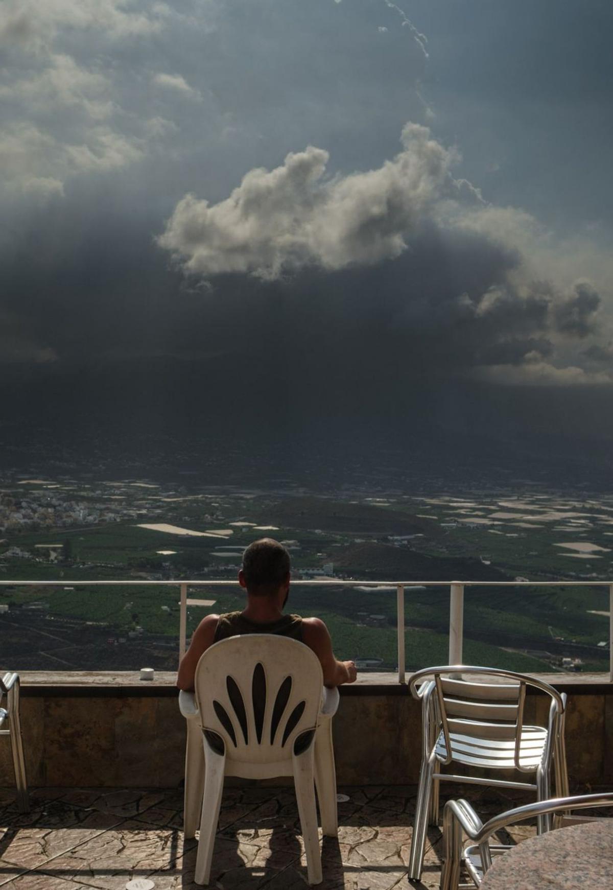 Un joven observa desde una terraza la erupción del Tajogaite. | ANDRÉS GUTIÉRREZ