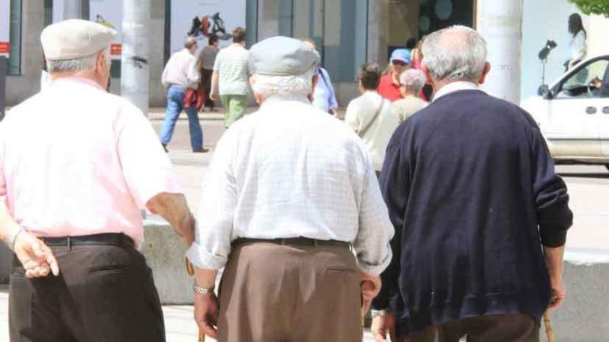 Varias personas mayores pasean por la calle.