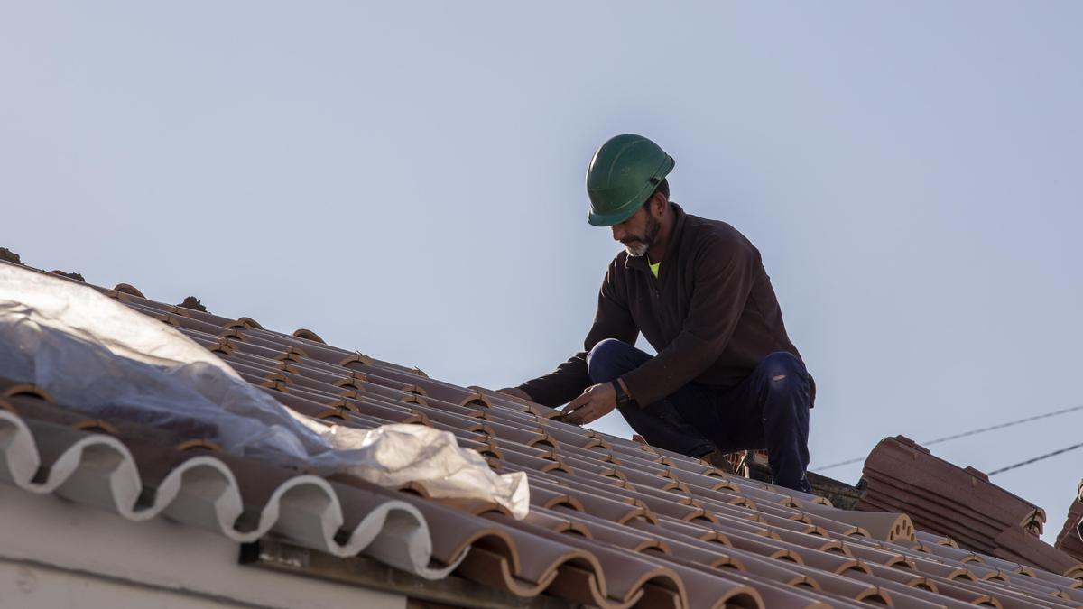 Un obrero realiza su labor en el tejado de una vivienda, en foto de archivo.