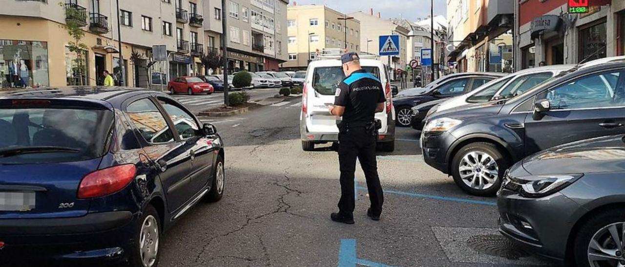 Policía multando a vehículos en doble fila en Costa da Tapia. |   // L.O.