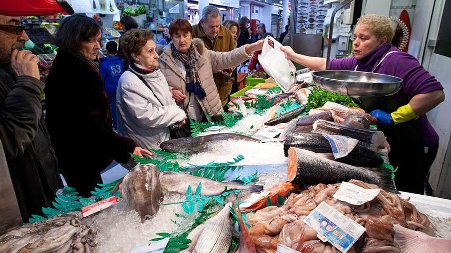 Carmen Domínguez entrega una bolsa con encargos navideños en su pescadería.