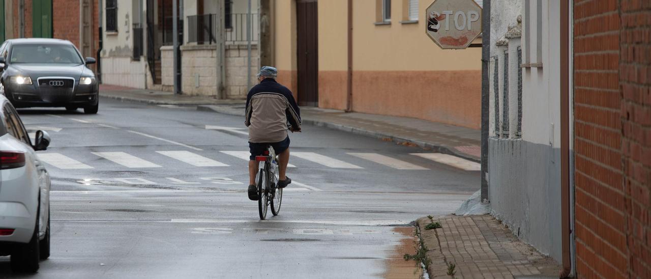 Una persona con la bicicleta en una calle mojada de Zamora