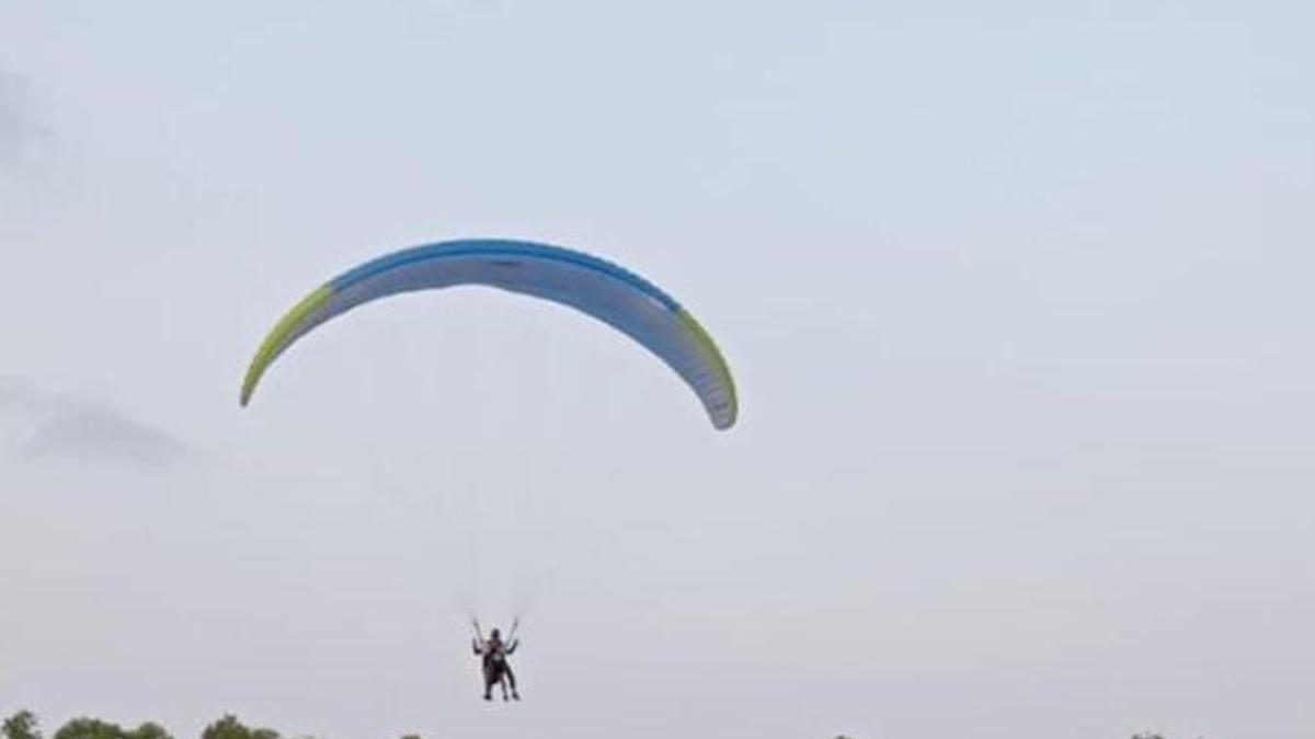 Un parapentista llegando a la pista de atletismo ‘Úrsula Ruiz’.