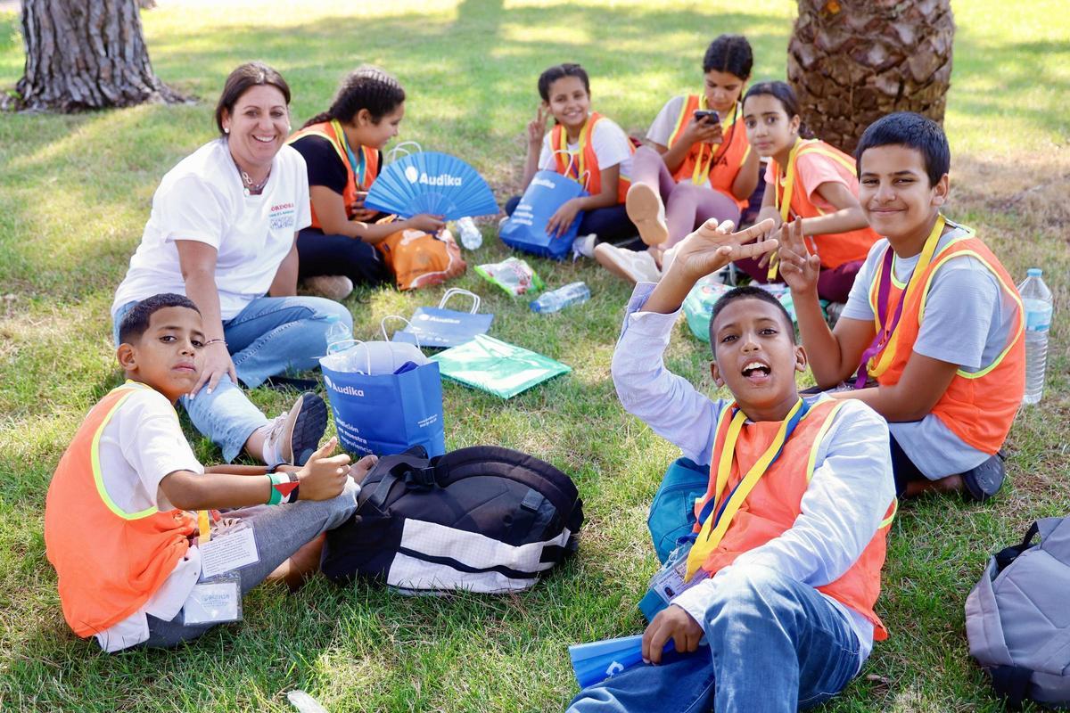 Un grupo de menores saharauis aguarda en el césped del albergue de Cerro Muriano antes de la recepción de las familias de acogida.
