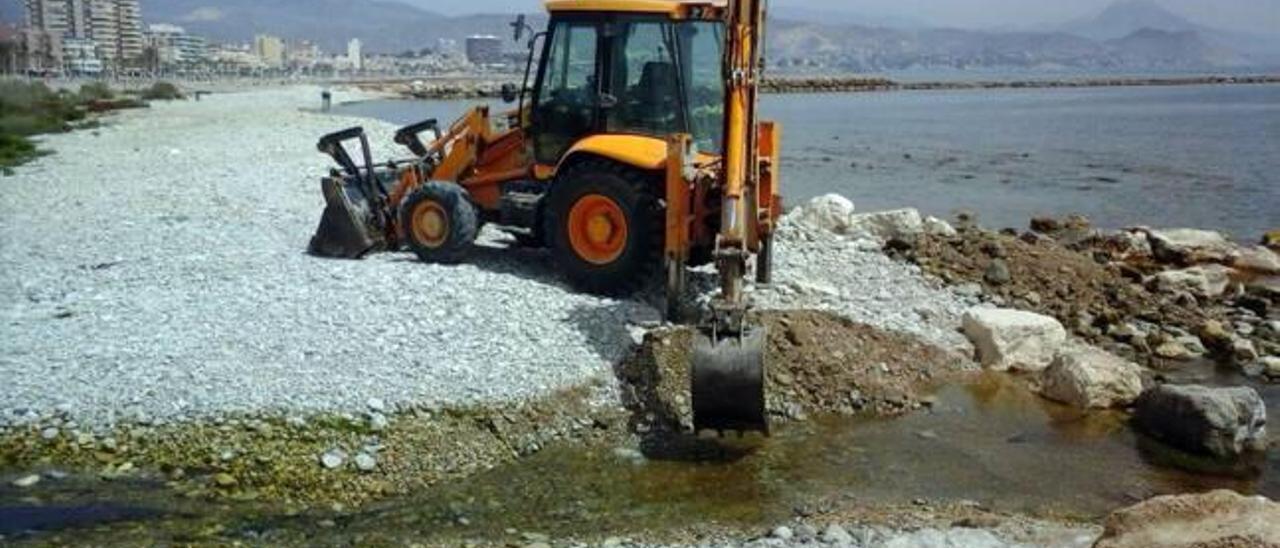 Una excavadora ampliando un canal para evitar el estancamiento del agua en el río Seco