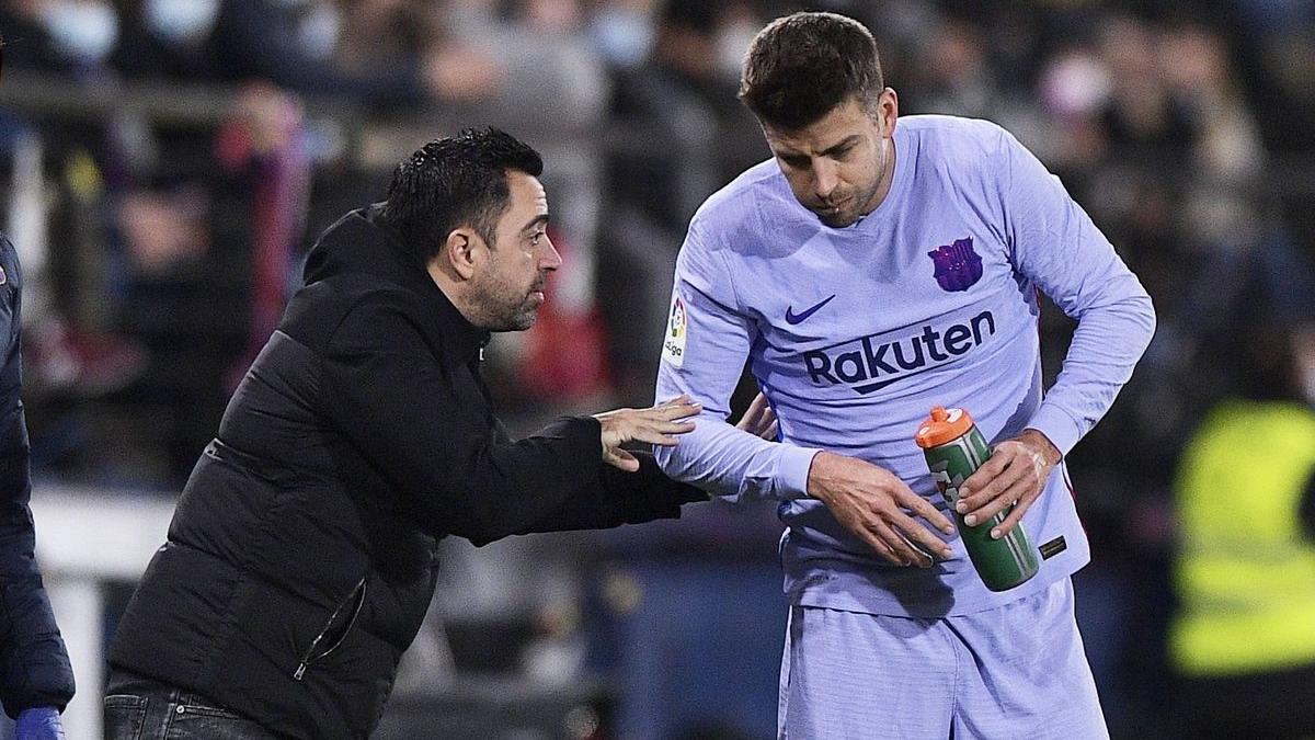 Xavi dona instruccions a Piqué durant un partit