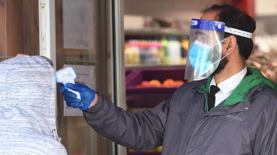 El personal comprueba la temperatura de un cliente a la entrada de un supermercado en el barrio chino de Londres..