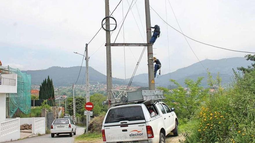 Varios operarios trabajan en la reposición de una línea de suministro eléctrico en la comarca. // S.Álvarez