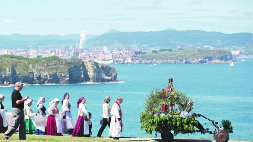 La procesión de San Lorenzo, en La Providencia, con el patrón en tractor y el litoral gijonés de fondo.