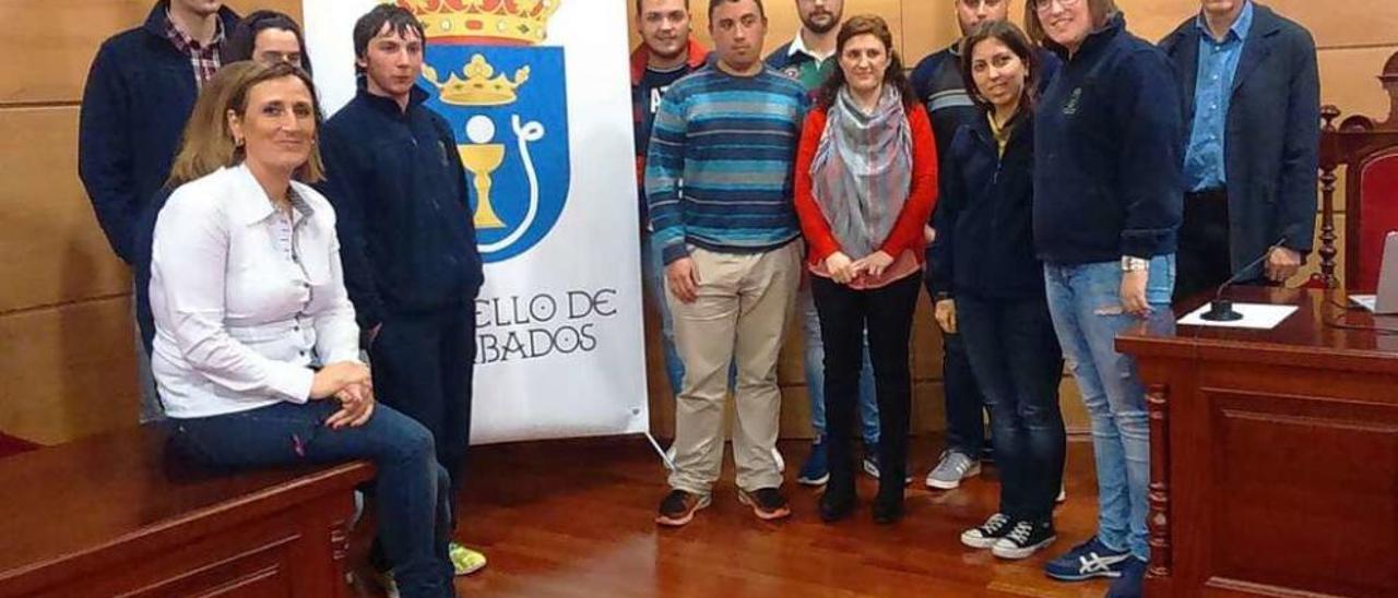 Concepción Ramos (primera izquierda), junto a los alumnos, la alcaldesa (centro) y el director del Obradoiro, Enrique Ferreiro (primero derecha), ayer en el salón de plenos. // Cedida Concello de Cambados
