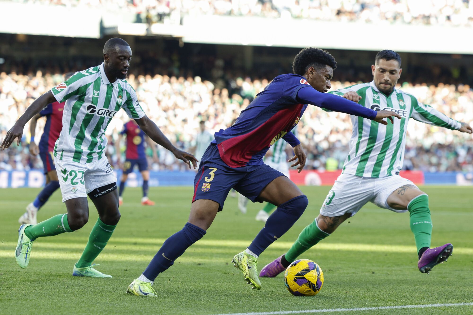 SEVILLA, 07/12/2024.- El defensa español del FC Barcelona Alejandro Balde (c) disputa un balón con el delantero argentino del Betis Chimy Ávila (d) durante el partido de la jornada décimo sexta de LaLiga EA Sports que disputan este sábado Real Betis Balompié y FC Barcelona en el Estadio Benito Villamarín de Sevilla. EFE/ Julio Muñoz