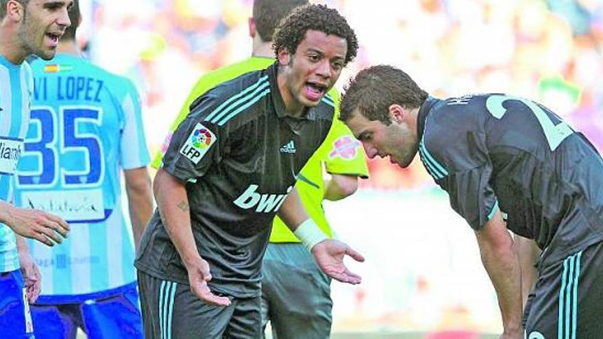 Marcelo dialoga con Higuaín durante el partido de ayer.