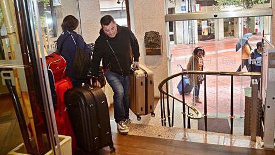 Varios viajeros con destino Galicia en el momento de alojarse en un hotel.