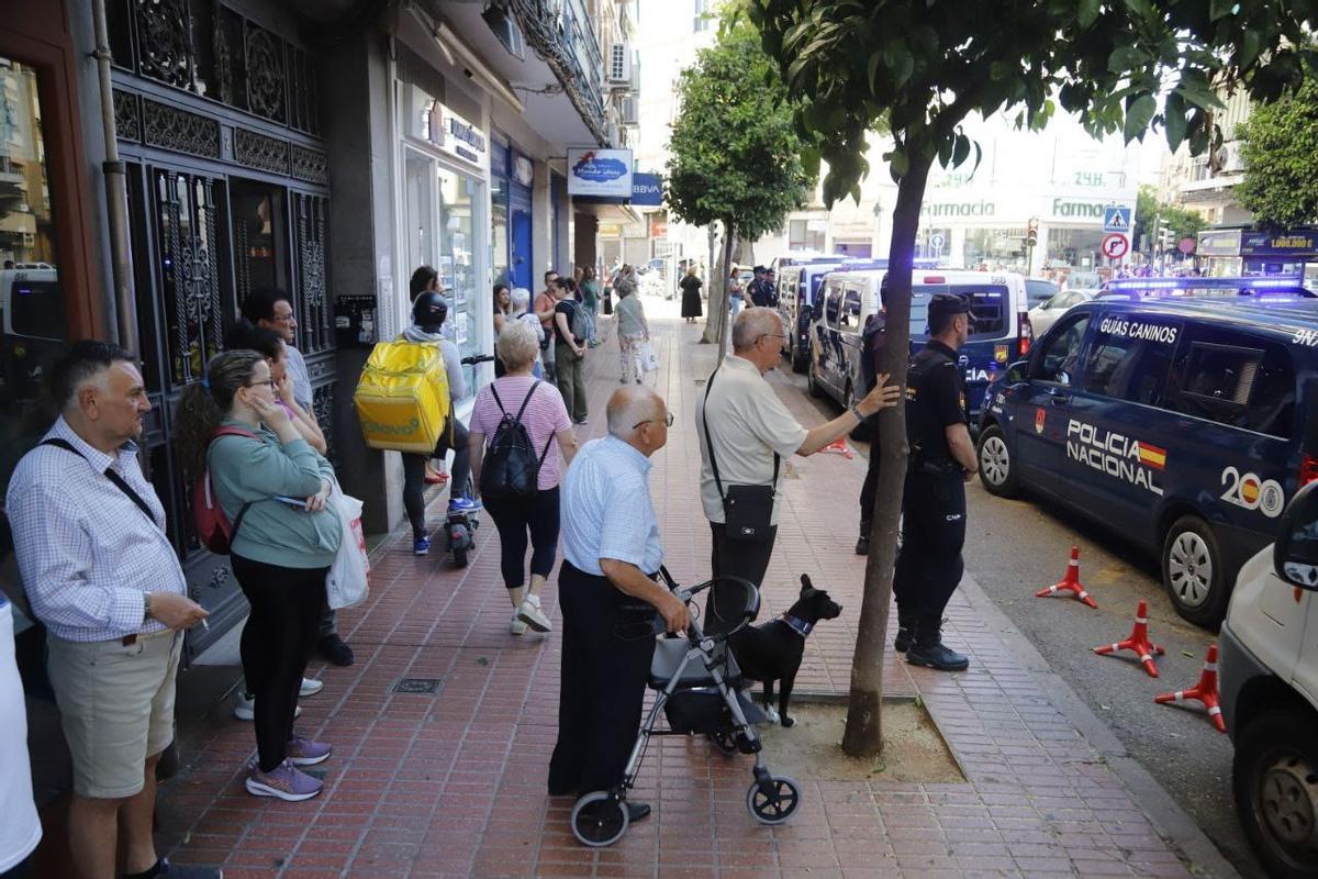 Vecinos y comerciantes observan la operación policial este miércoles en La Viñuela.