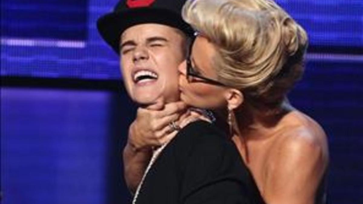La presentadora de la gala, Jenny McCarthy. besa a Justin Bieber durante la entrega de premios.