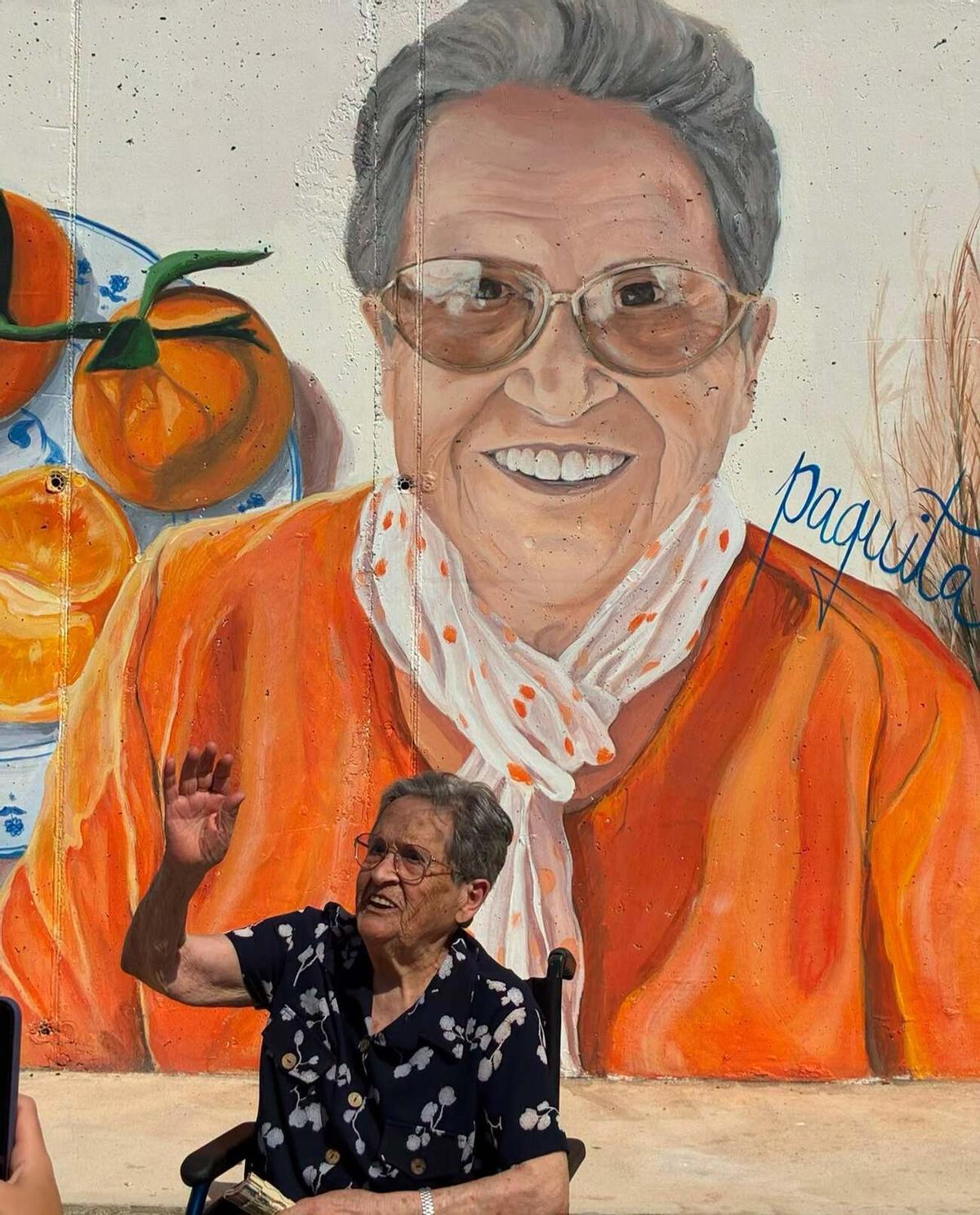 La centenaria de Daimús, Paquita, ante su imagen en el mural