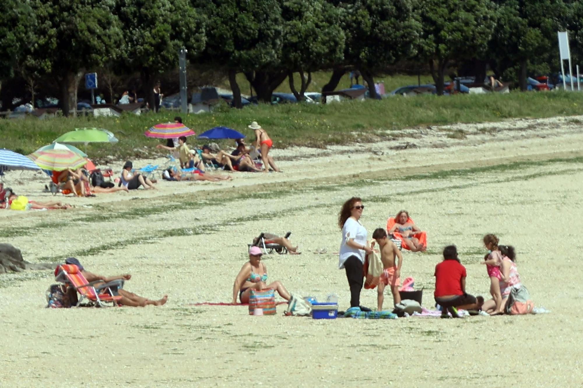 Arousanos y turistas disfrutan en las playas de un anticipio del verano.