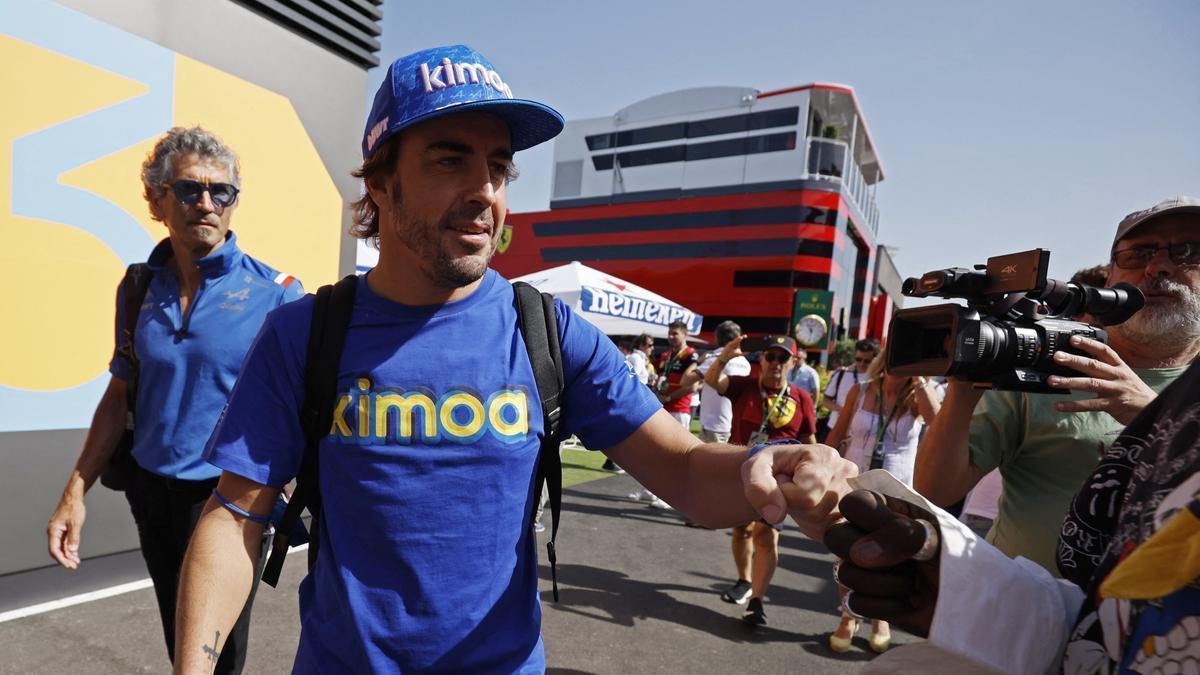 Fernando Alonso saluda a varios aficionados en el paddock.