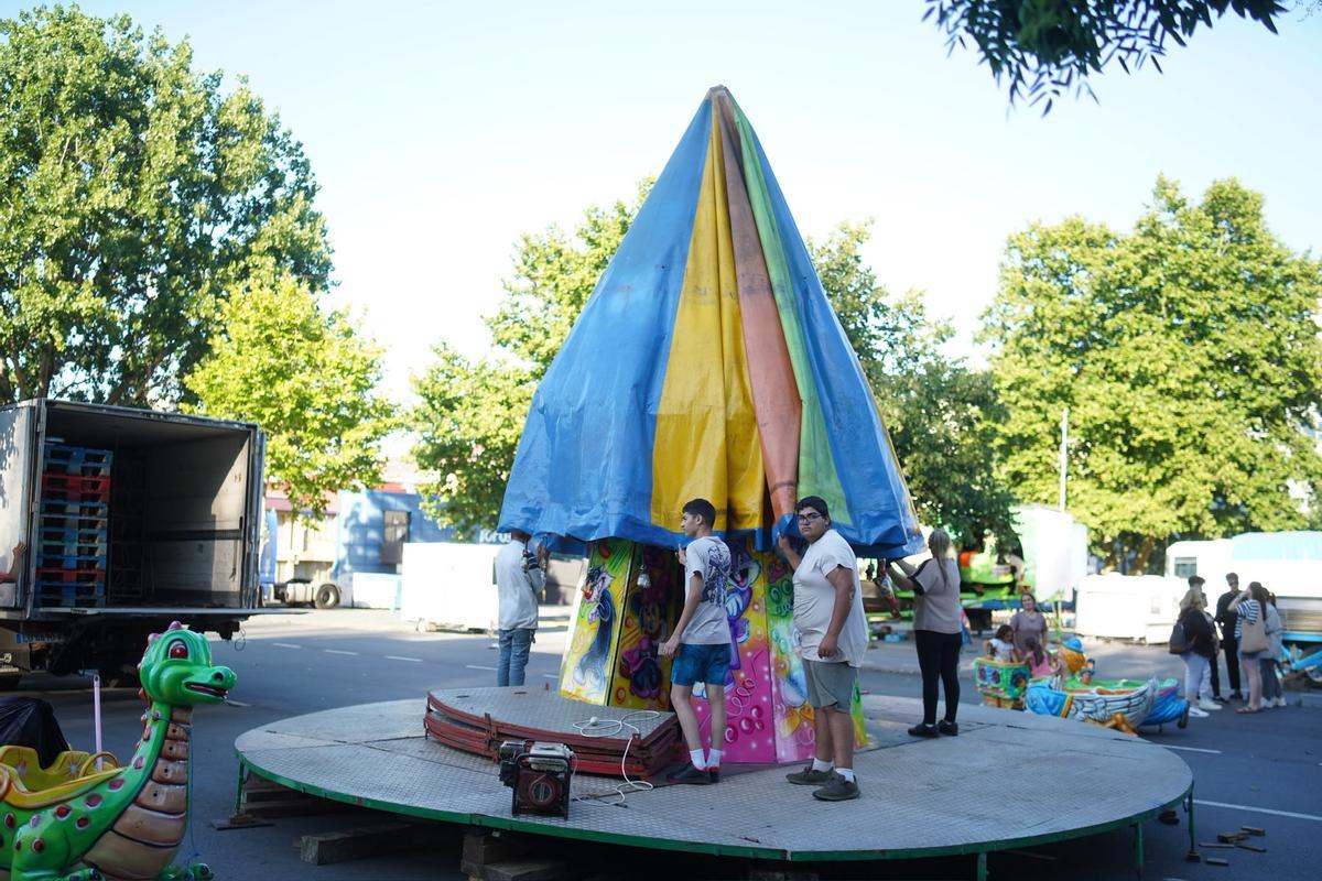 Montaje de las atracciones de las fiestas de Monte Martelo, en la explanada del aparcamiento de la piscina de Elviña.