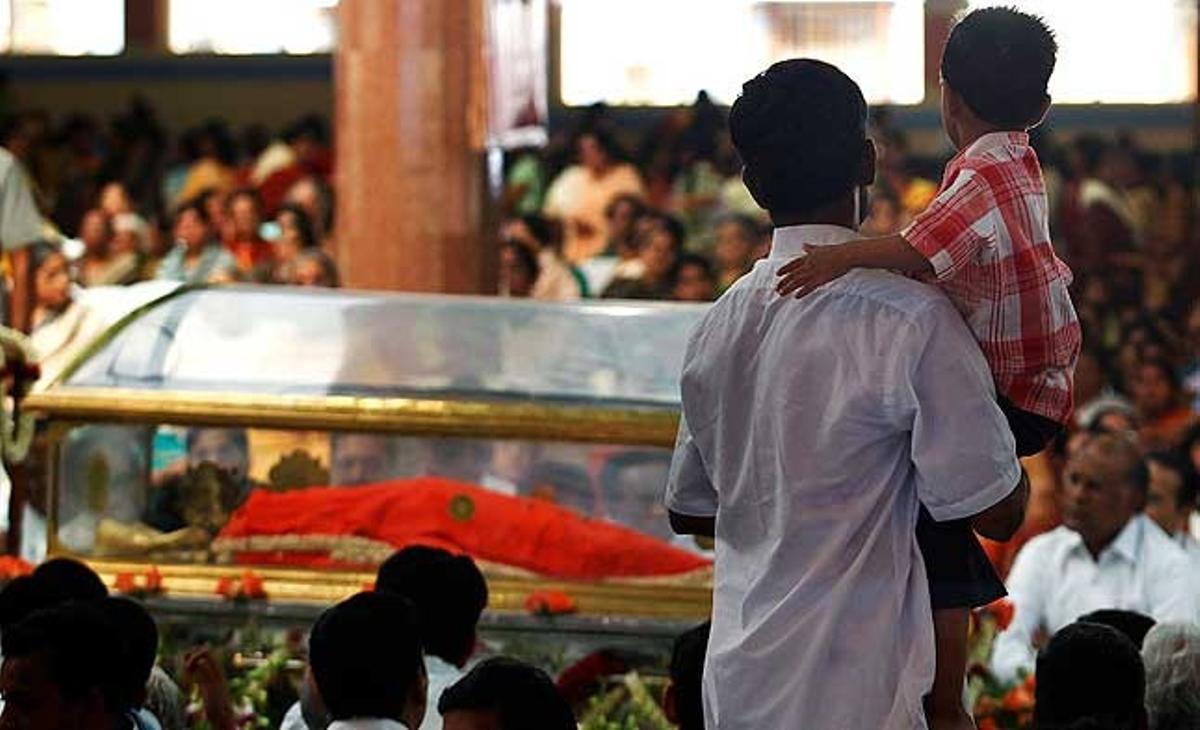Un devot sosté el seu fill mentre ofereix els seus últims respectes al recentment desaparegut mestre espiritual Sri Sathya Sai Baba, al seu ’ashram’ de Puttaparthi, al sud de l’Índia.