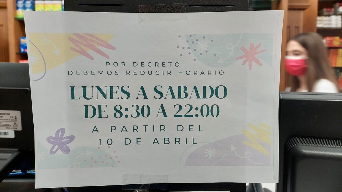 Cartel en una farmacia que anuncia la reducción de su horario.