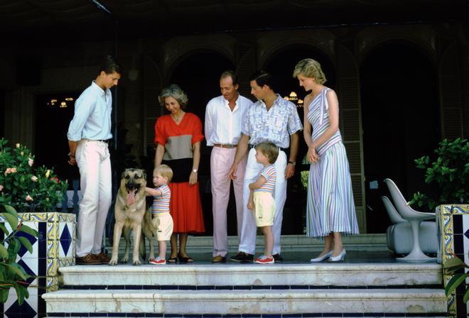 Los reyes Juan Carlos y Sofía y el príncipe Felipe junto a al príncipe Carlos, Lady Di y sus hijos William y Harry, que acarician al pastor alemán Arky, durante su visita a Palma de Mallorca en el verano de 1987