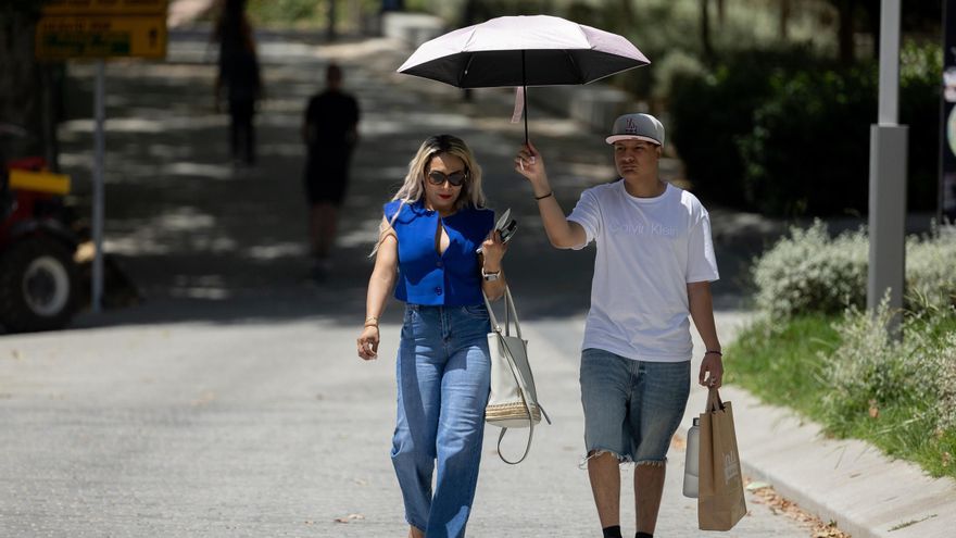 Varias personas paseando bajo el sol.