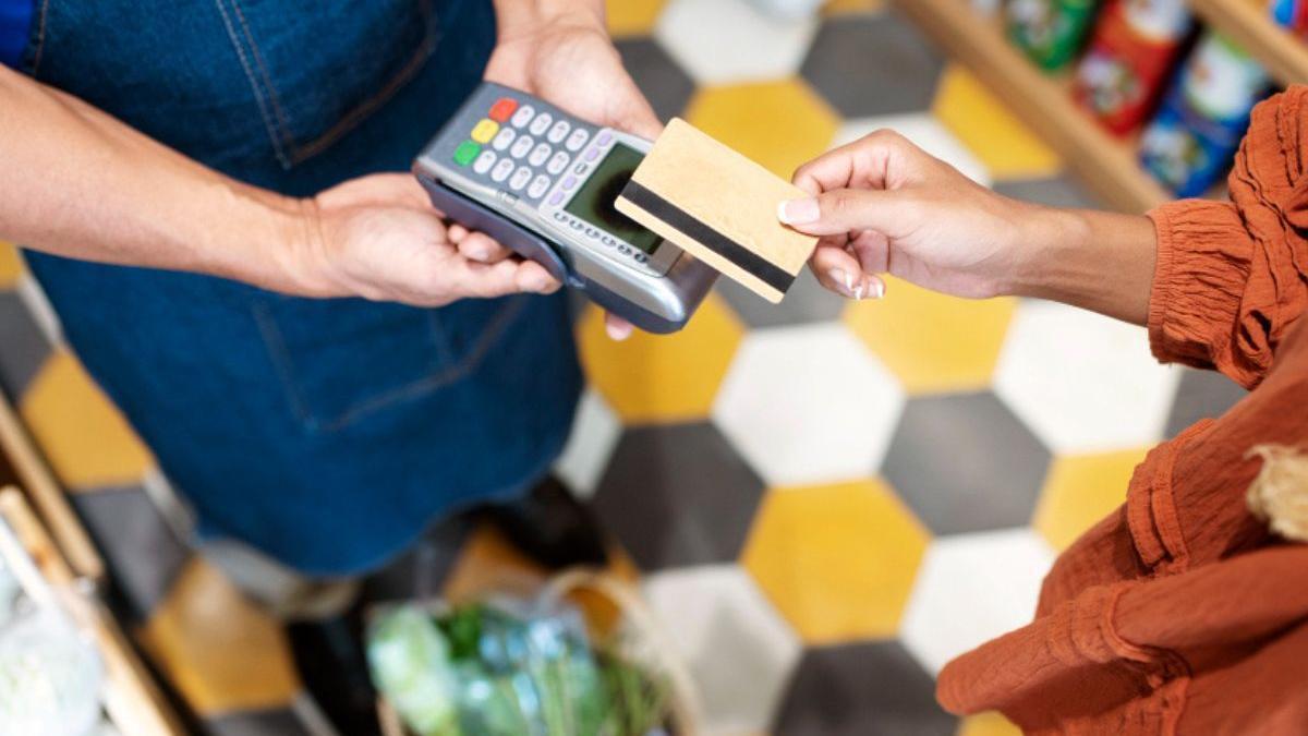 Una persona paga con tarjeta en una tienda.