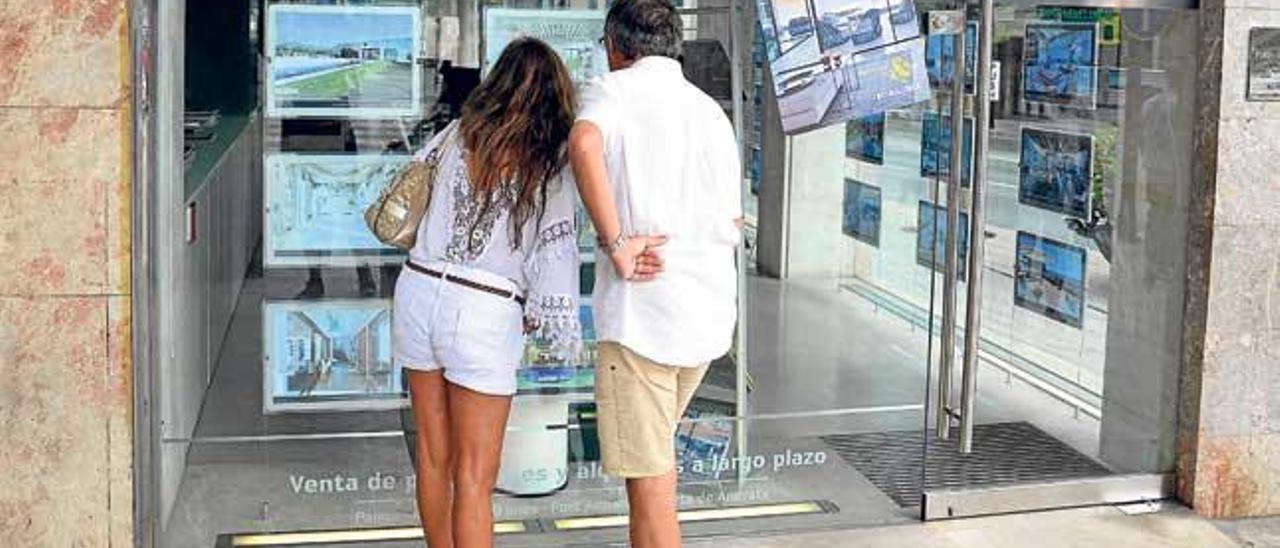 Dos turistas observan, el sábado, las opciones de compra de una inmobiliaria del centro de Palma.