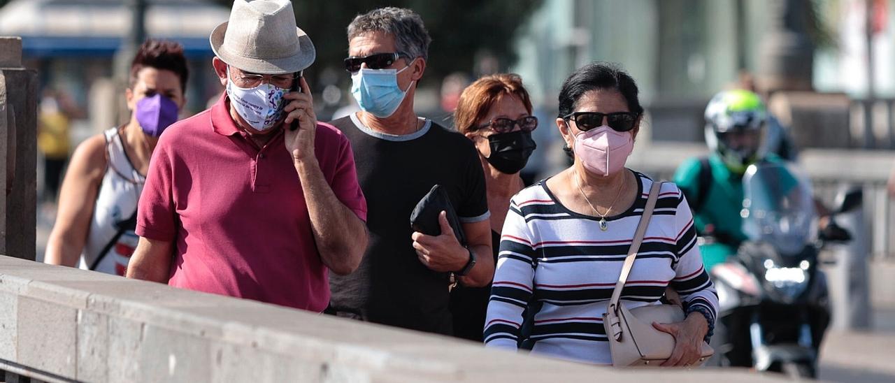 Varias personas con mascarilla transitan por Santa Cruz de Tenerife.